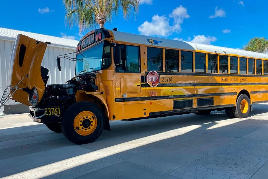 School bus with its hood open for AC repair